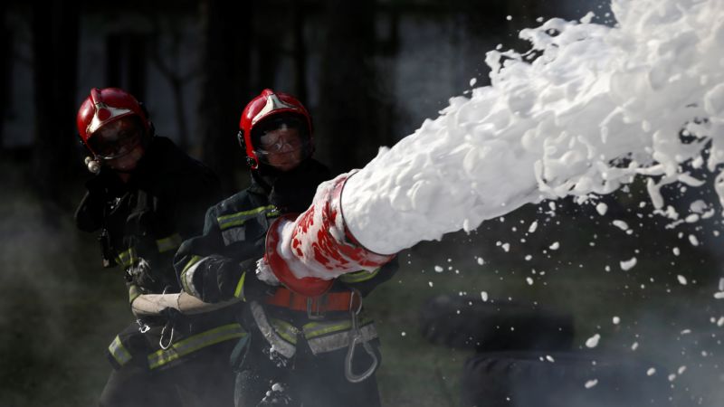 Extinguishing the fire. Firemen are working. Fill the foam with a fire. Resolute firefighters. Fight fire.